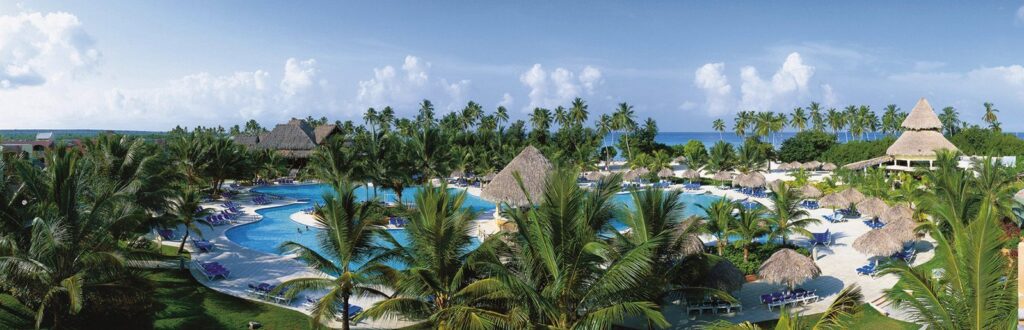 pool surrounded by palm trees at Be Live Collection Canoa