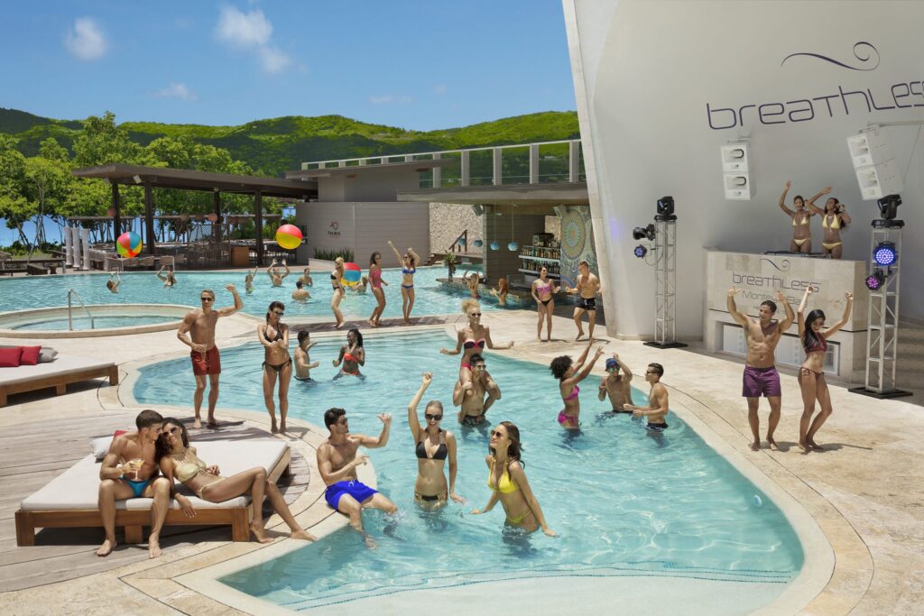 large group dancing in pool with DJ