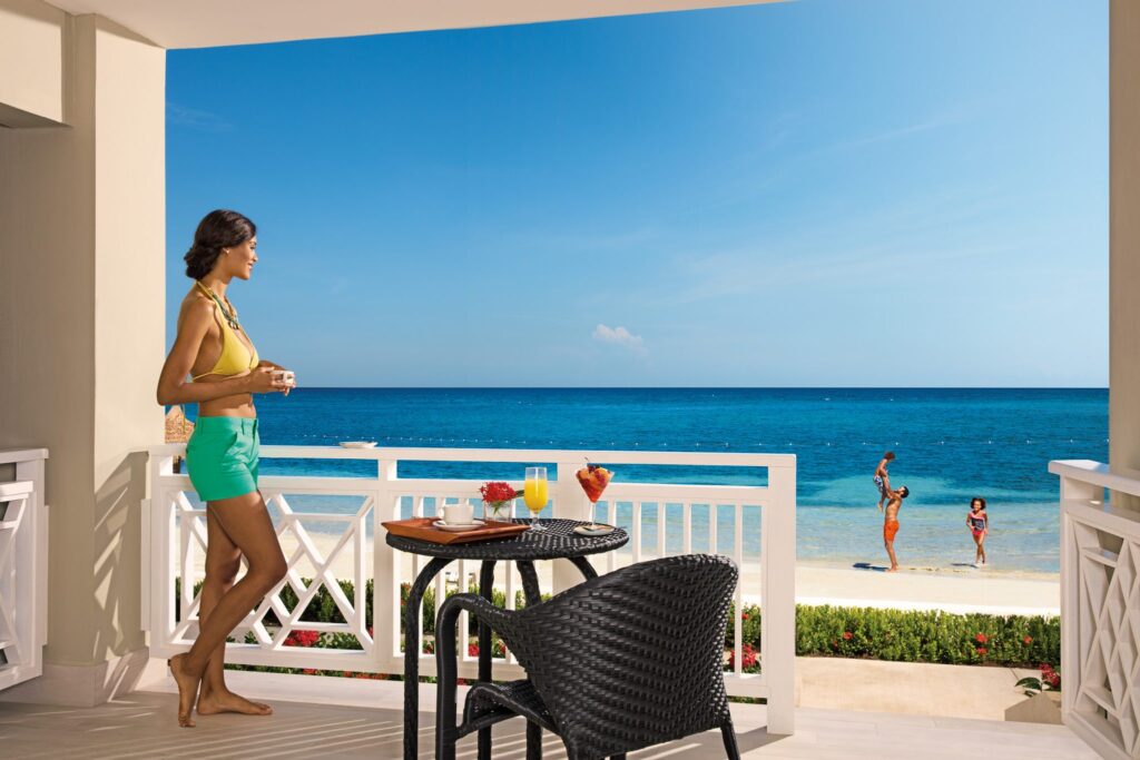 woman standing on resort balcony looking at beach