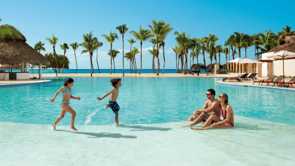 couple and two children playing in luxurious pool