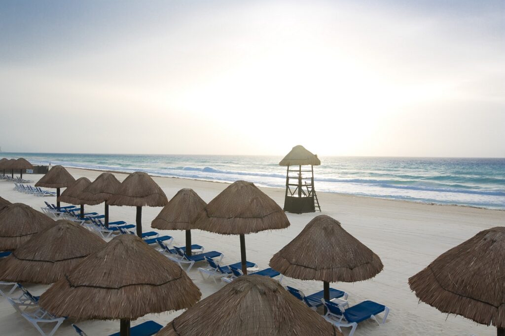 pristine beach with palapas and beach chairs