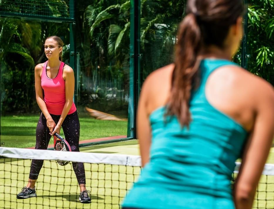 two women playing tennis at resort