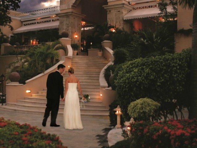 bride and groom on large staircase at resort