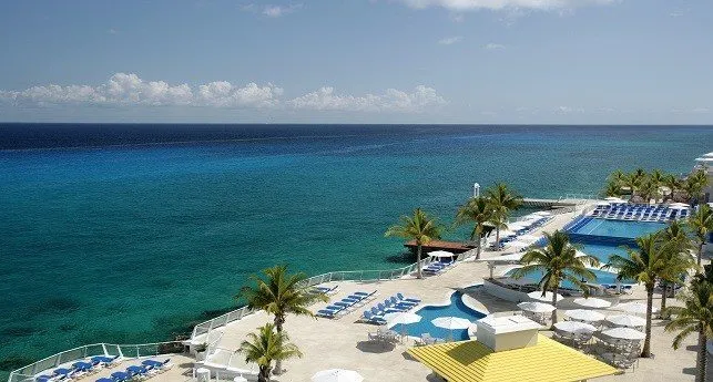 pool and lounge chairs overlooking turquoise ocean water