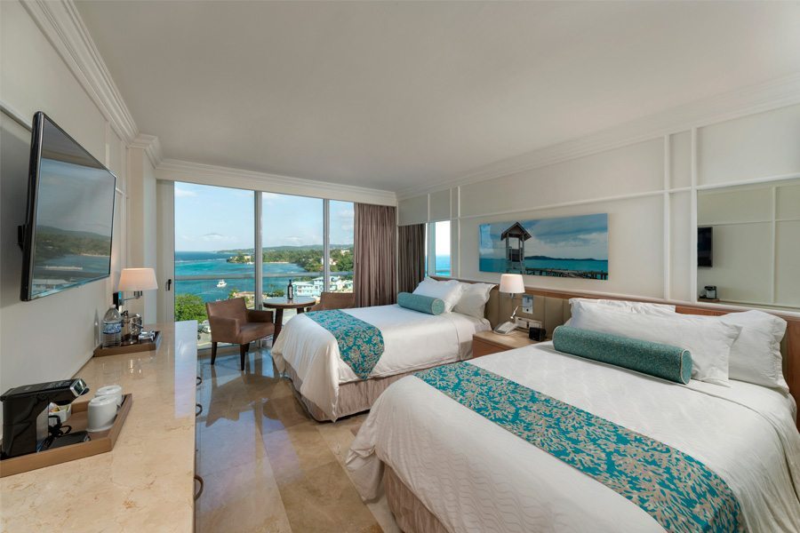 room with two double beds and ocean view