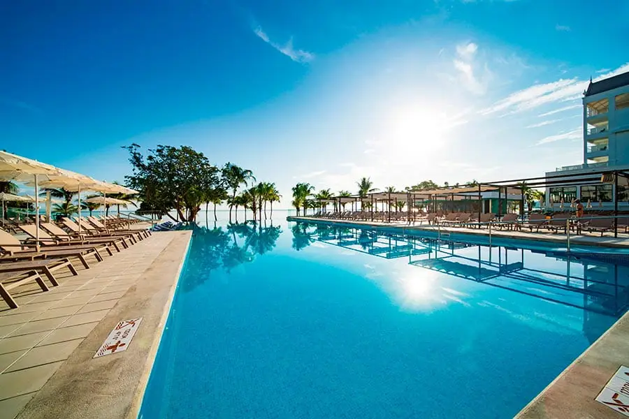 large pool surrounded by lounge chairs