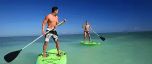 couple paddle boarding in ocean