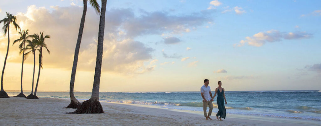 couple walking on beach at sunset