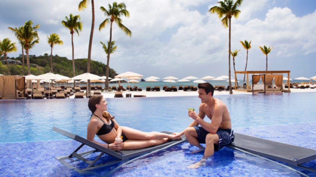 A couple using loungers in pool