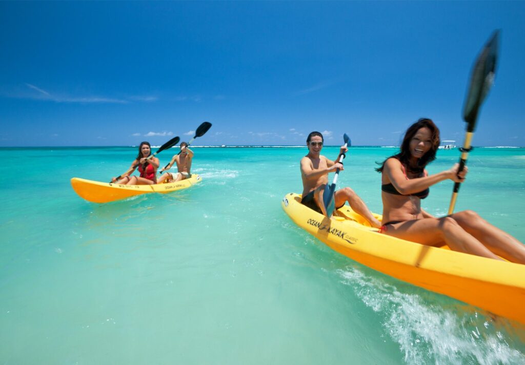 couples kayaking in clear blue ocean water