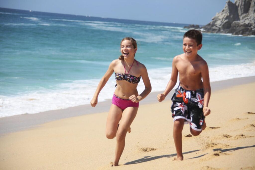 two children running on the beach