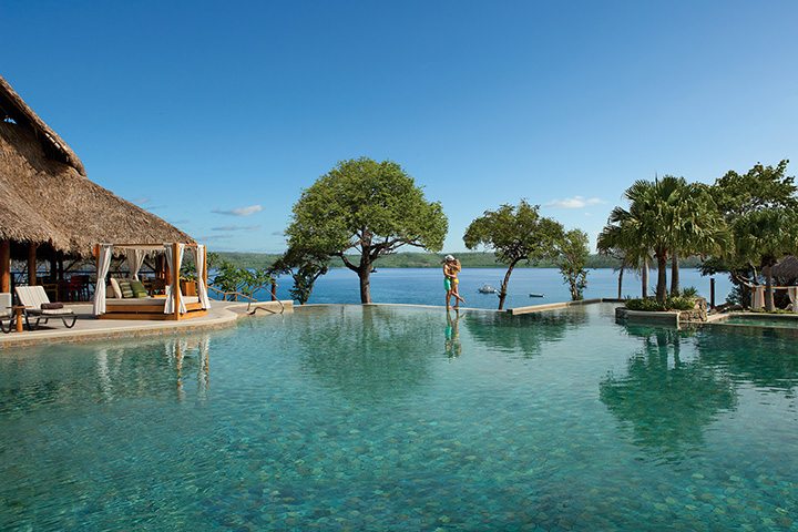 couple kissing on the edge of infinity pool