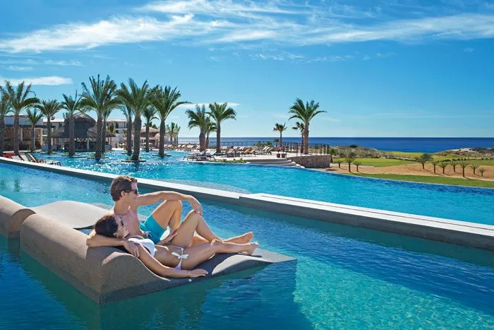 couple lounging in pool overlooking ocean