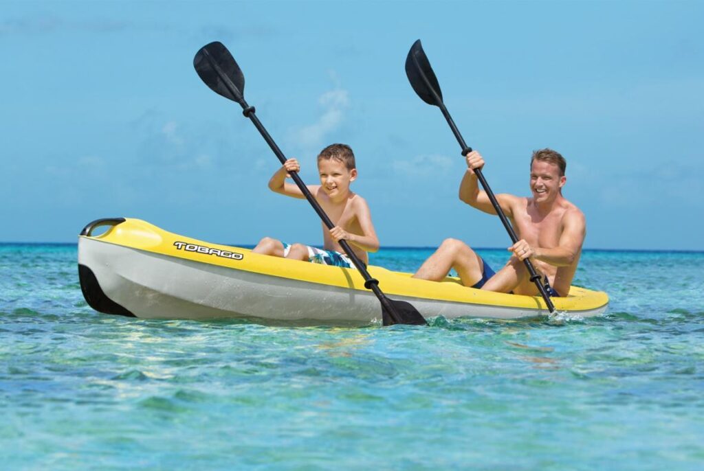 man and boy kayaking in ocean