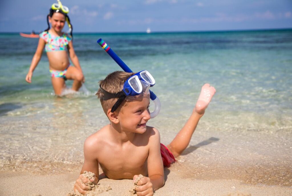 two children snorkeling on beach