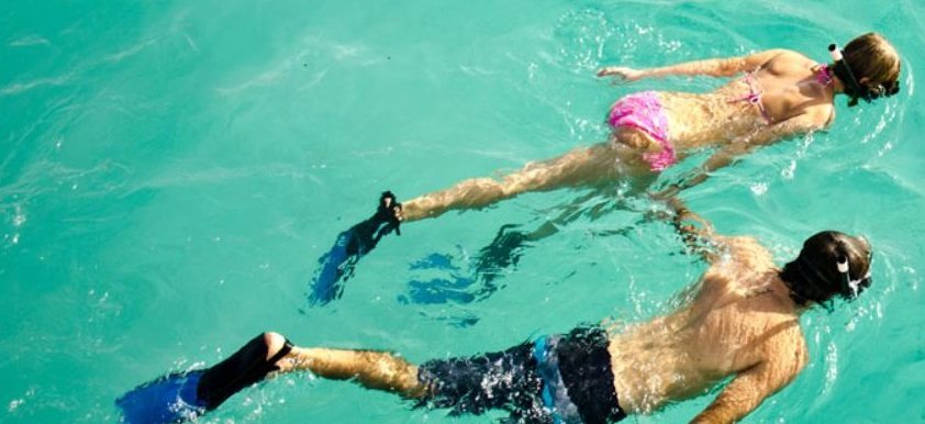couple snorkeling in clear water