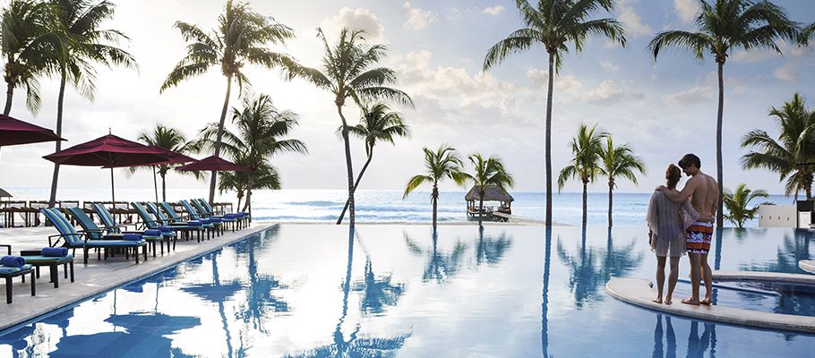 beachside pool surrounded by palm trees at Azul Beach Resort in Playa Del Carmen
