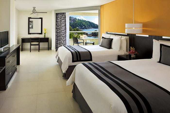 suite at Dreams huatulco resort and spa with two beds and large balcony