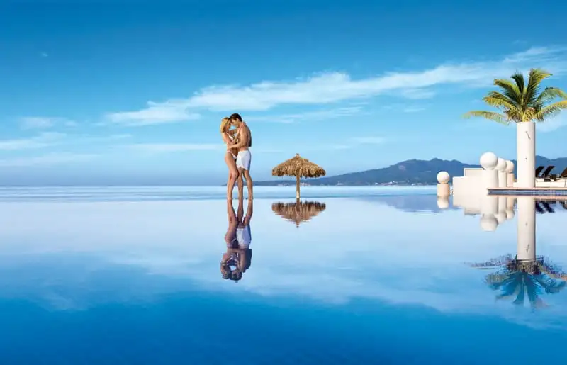 couple embracing on the edge of infinity pool