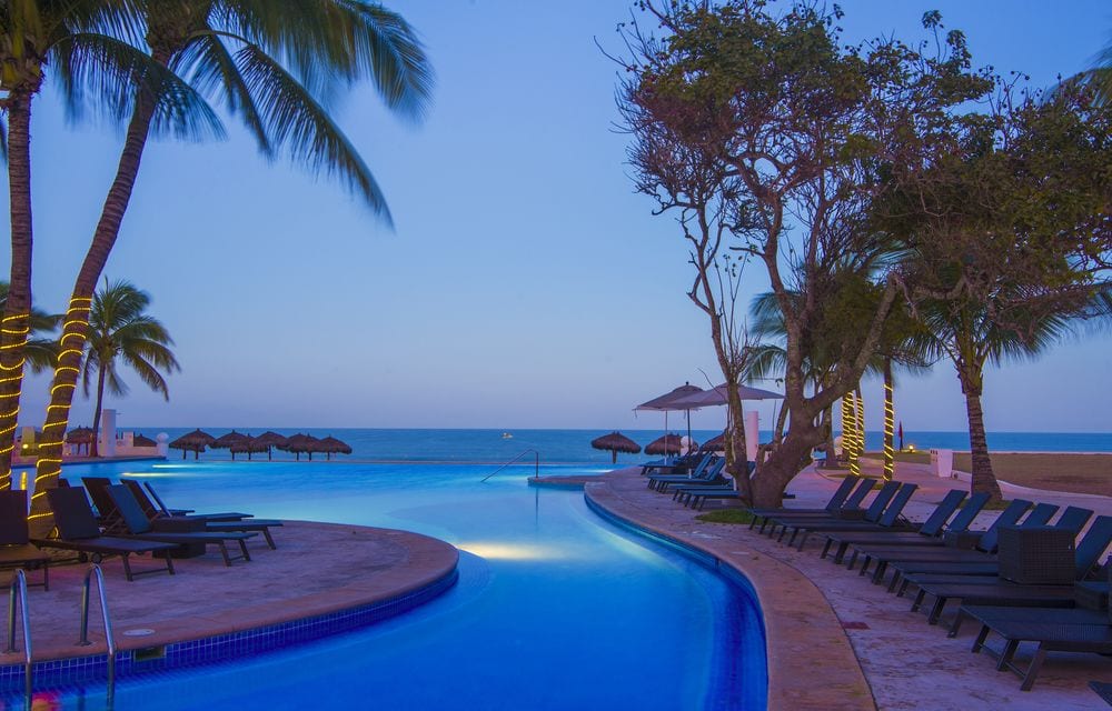 resort pool and beach at sunset