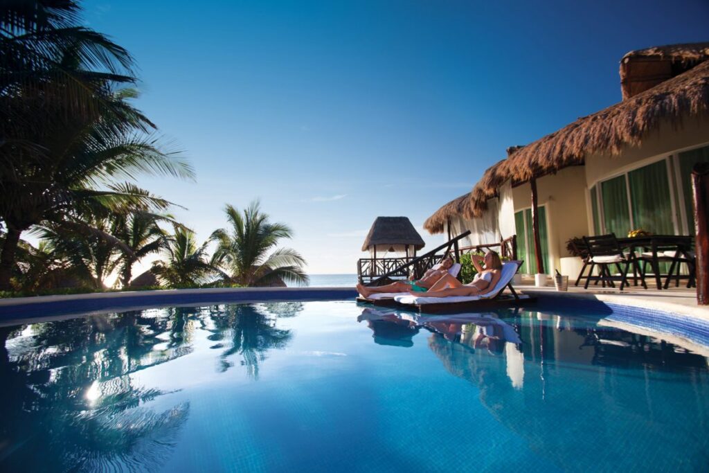 couple laying on sun loungers in private pool