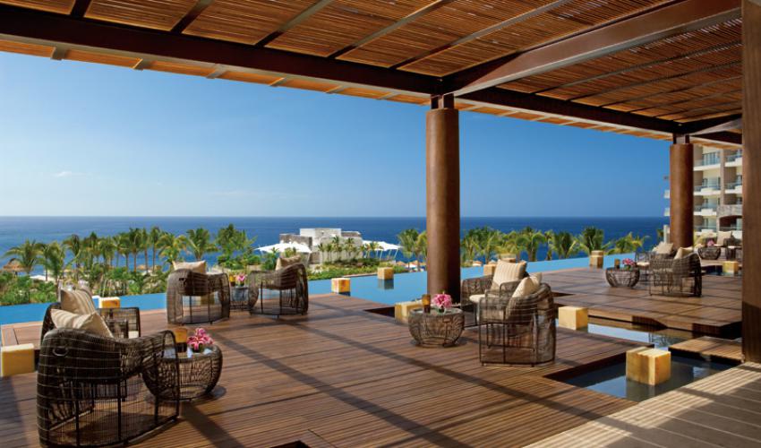 outdoor lounge area overlooking pool and ocean