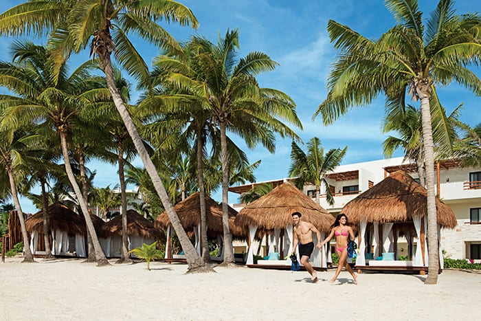 couple walking on white sand beach