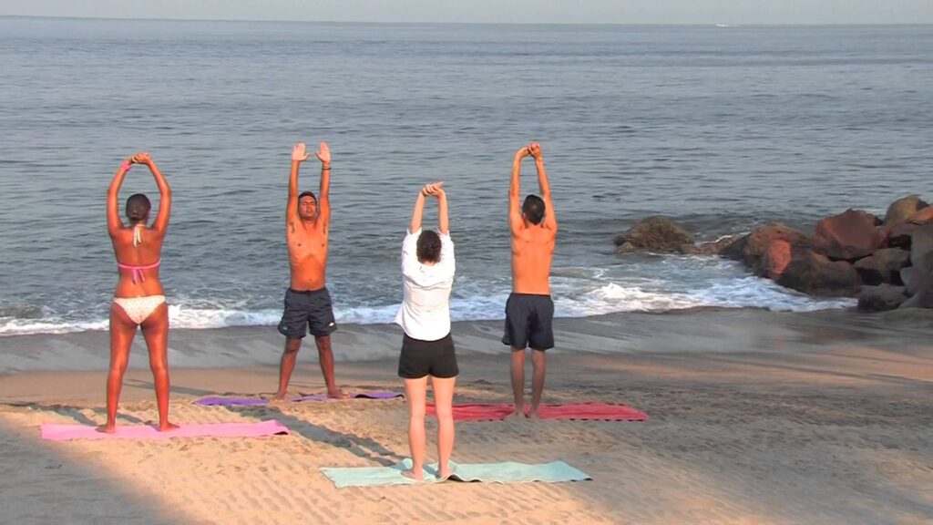 two couples doing yoga on the beach